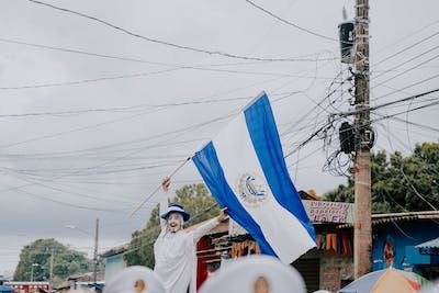 free-photo-of-man-waving-an-el-salvadoran-flag-on-the-street